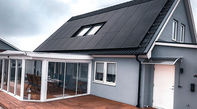 Solcellspanel på taket Blågrått hus med solcellspanel på taket
