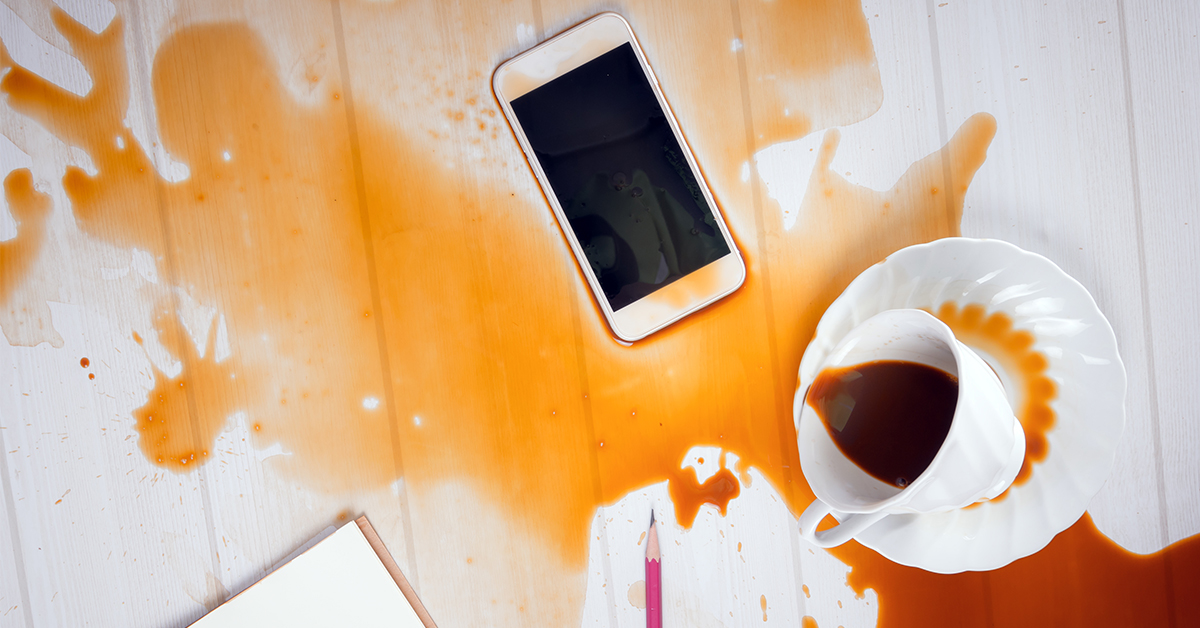 Lär dig vad IP-klassificeringen betyder En telefon på ett skrivbord med kaffe spillt över den