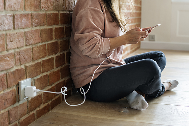 Det bästa sättet att ladda mobilen Kvinna med mobil som laddar den
