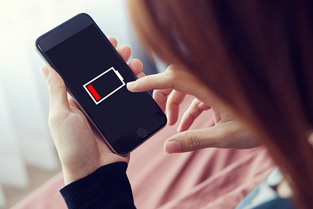Spara batteri med strömsparläge Kvinna med mobil som nästan har slut på ström