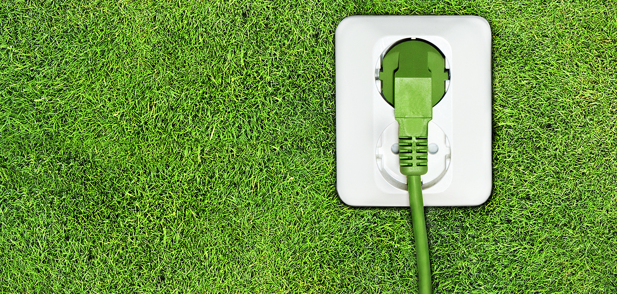 Smarta enheter kan hjälpa dig att spara både pengar och energi - samtidigt. En grön strömsladd som är inkopplad i ett uttag på en grön bakgrund