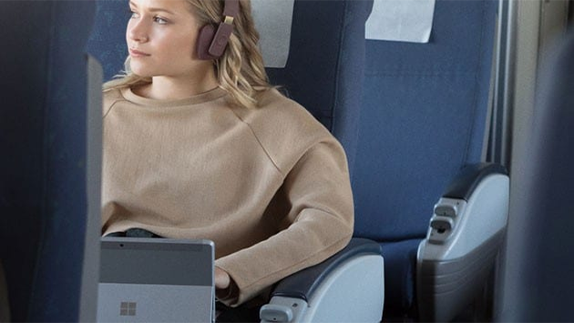 Surface Go är både mångsidig, anpassningsbar och ultraportabel Bild av en unga kvinna på ett tåg med Surface Go i handen
