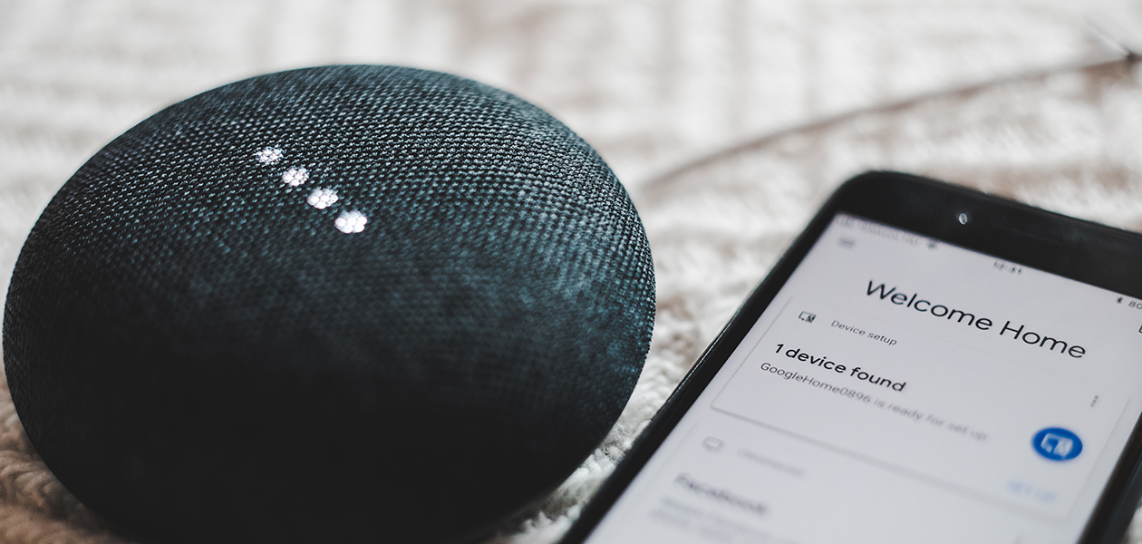 Få ut max av din Google Home En Google Home Mini högtalare bredvid en smartphone.