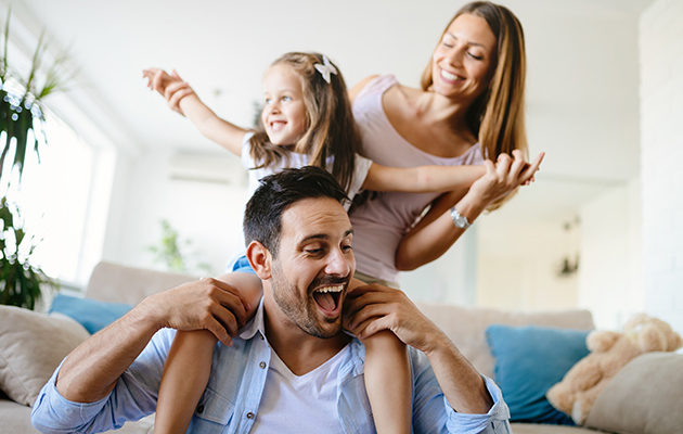 Google Home kan avändas av flera personer.
En pappa som håller sin leende dotter på sina axlar..