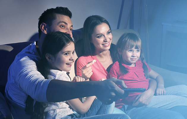 No need for remote controls anymore En familj som sitter på en soffa och tittar på TV. Pappan håller i en fjärrkontroll.
