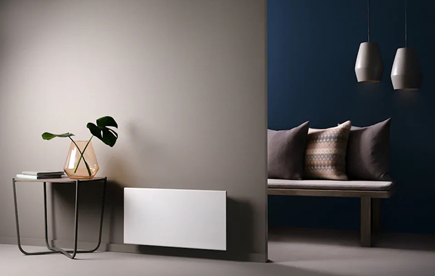 Kontrollera värmen på avstånd Ett vitt element monterat på en brun vägg i ett minimalistiskt dekorerat rum