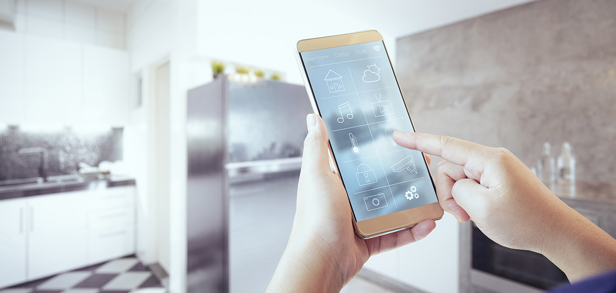 Styr dina smarta apparater med Home Connect Händer som håller en smartphone framför ett kök