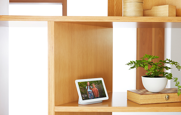 Den perfekta, digitala bildramen Google Nest hub visar familjebilder på en hylla
