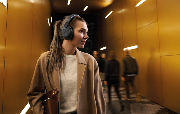 Aktiv brusreducering är en teknologi som skickar ut signaler som nollar ut brus runt om dig Kvinna med Jabra Elite 85h