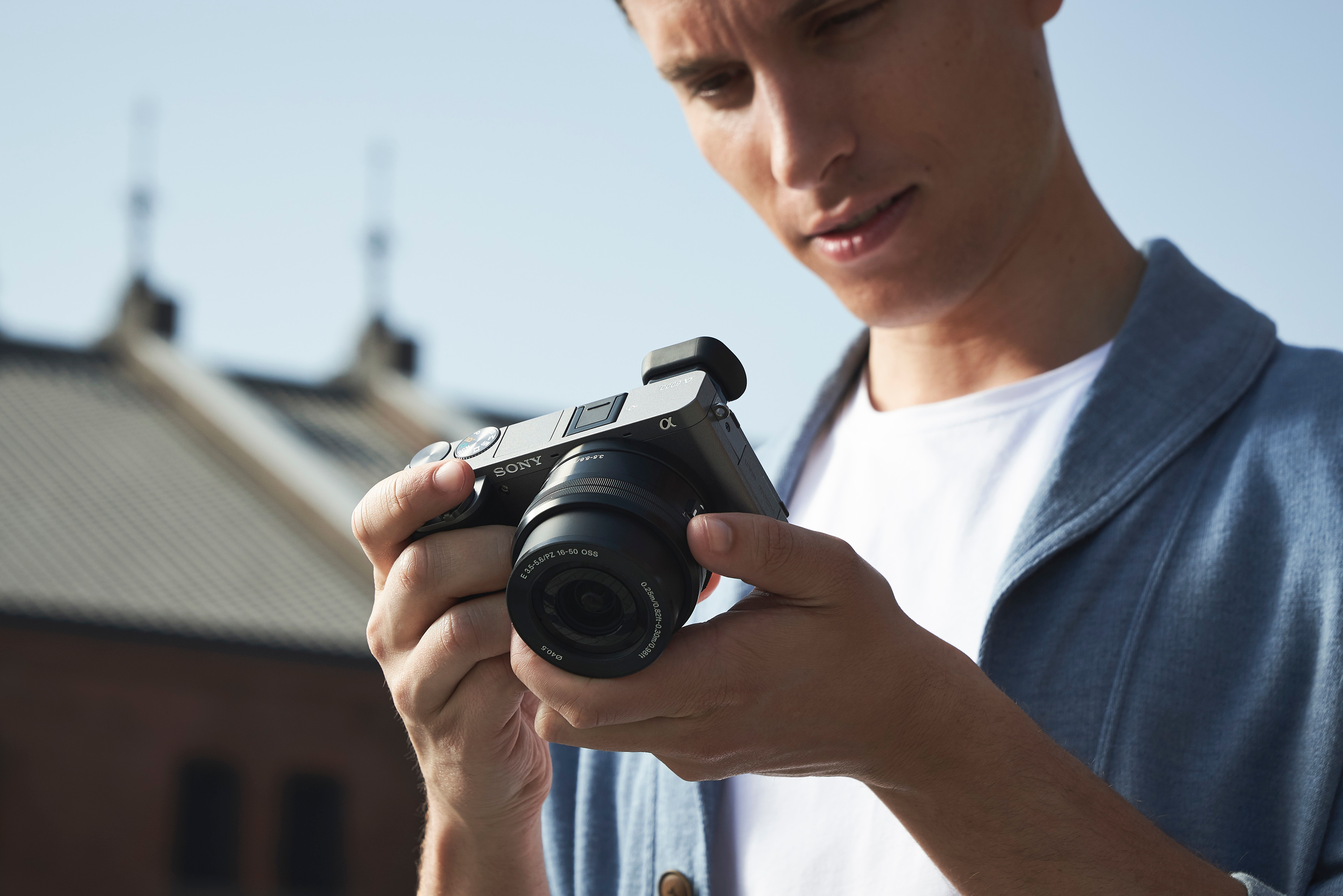 Sony A6000 En man håller en svart A6000 och ser på skärmen