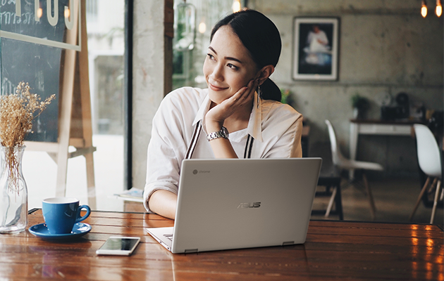 ASUS Chromebook Flip Kvinna sitter vid ett bord med en ASUS Chromebook Flip C434 och ler
