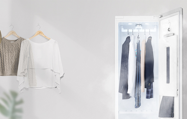 Inga skrynklor eller lukter En vit och en beige tröja händer på väggen, kavajer och jeans hänger i LG Styler