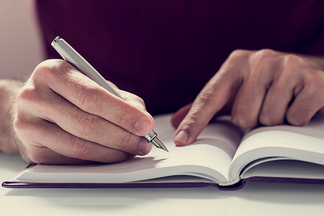 Evernote Person antecknar i en bok
