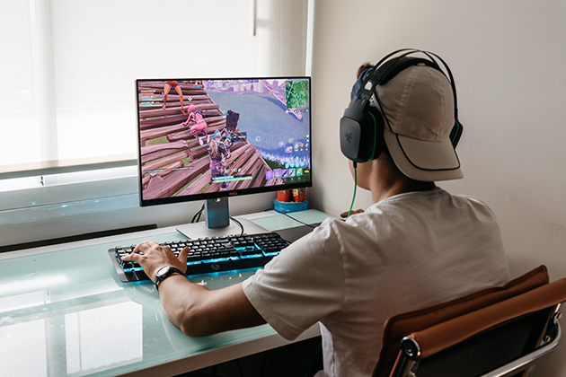 Gaming kräver en optimal router En pojke som sitter framför en dator och spelar