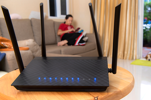 Tjocka väggar försämrar WiFi-signalerna En router på ett bord och en flicka i bakgrunden