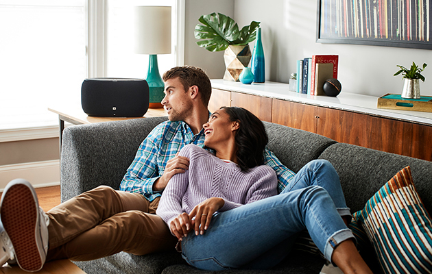 Drivelement Par i soffa med högtalare i bakgrunden