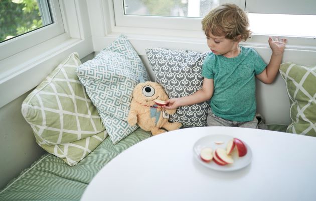 Tile Mate är en prisvärd tracker Pojke som matar ett äpple till ett gosedjur med en Tile tracker