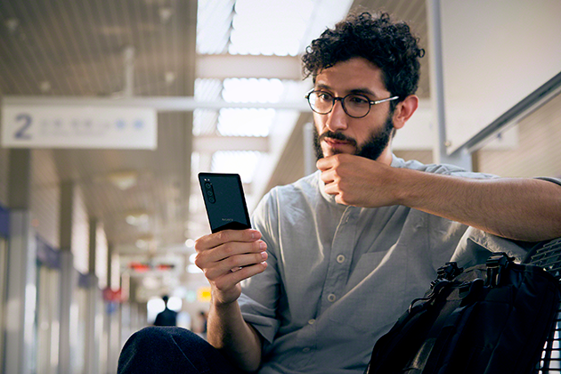 Sony Xperia 5 har en kompakt design som ligger perfekt i handen Man sitter med Sony Xperia 5 i handen