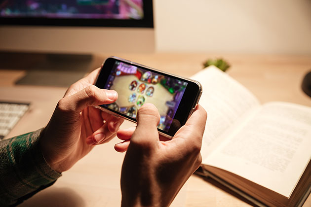 Spel tar plats på telefonen Person spelar spel på telefonen