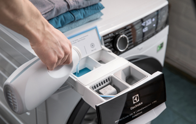 AutoDose – perfekt dosering En hand som fyller på en tvättmaskin med tvättmedel