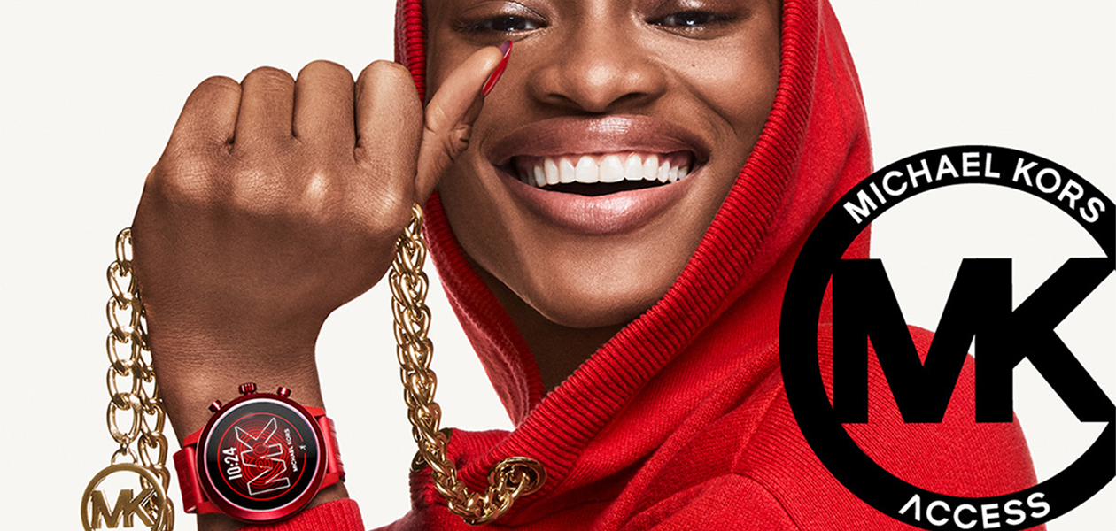 Michael Kors – Nya 5e generations smartwatch Kvinna i röd tröja med guld MC-kedja och röd MC-klocka