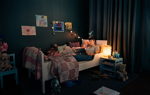 Batteritid Mor och dotter ligger i sängen med Microsoft Surface Pro 7