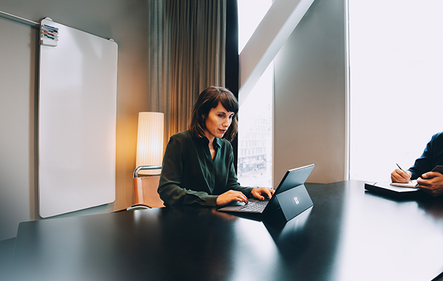 Snyggt, stilfull, praktisk och lätt design Kvinna skriver på en Microsoft Surface Pro 7