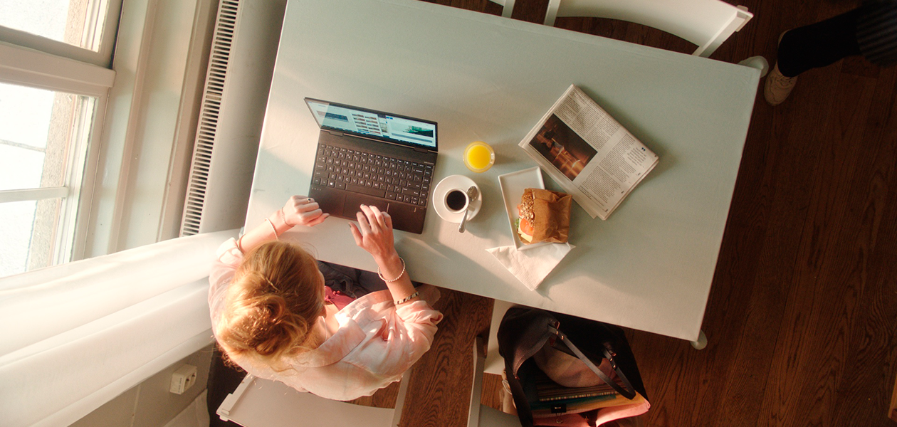 Vilka funktioner har den bästa bärbara datorn? Kvinna sitter vid Cafe med en HP Envy X360