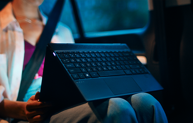 Multifunktionella HP Envy x360 En kvinna med en HP Envy x360 laptop i bilen