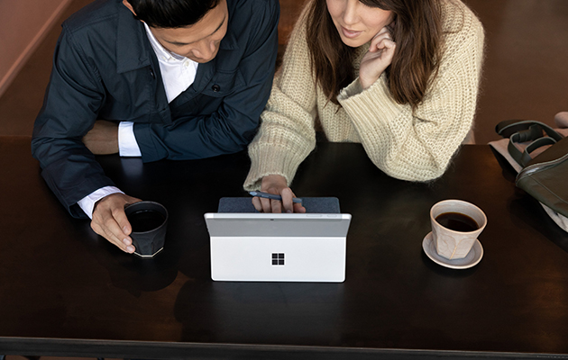 Surface Go 2 kan hantera alla dags att göra-uppgifter Kvinna och man sitter på fik med Surface Go 2 framför sig