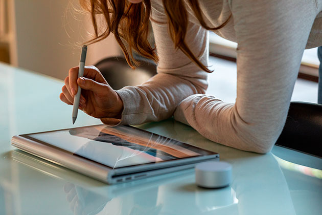 Surface Book 3 er innovation i enhver detalje Kvinna lutar sig över en Surface Book 3 på ett bord