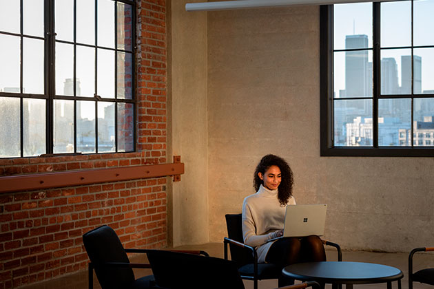 Surface Book 3 är byggd med toppresetanda Kvinna som sitter med en Surface 3
