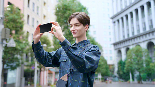 Tre kameror, tre linser, otaliga möjligheter En ung man som använder en Sony Xperia 10 för fotografering