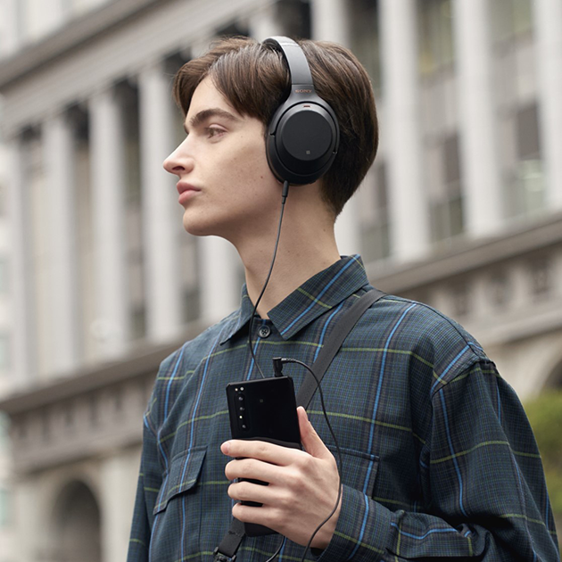 Den ultimata ljudkvaliteten - trådbunden eller trådlös. Du får också balanserat stereoljud med högtalarna i telefonen Man med Sony hörlurar på sig samt en Sony Xperia 1 II i handen