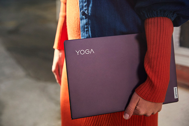 Lenovo Yoga Slim 7 har en elegant design En kvinna som håller i Lenovo Yoga Slim 7