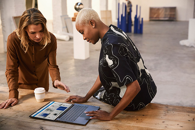 Lenovo Yoga Slim 7 kan klara av tunga uppgifter Två kvinnor som tittar på en öppen Lenovo Yoga Slim 7