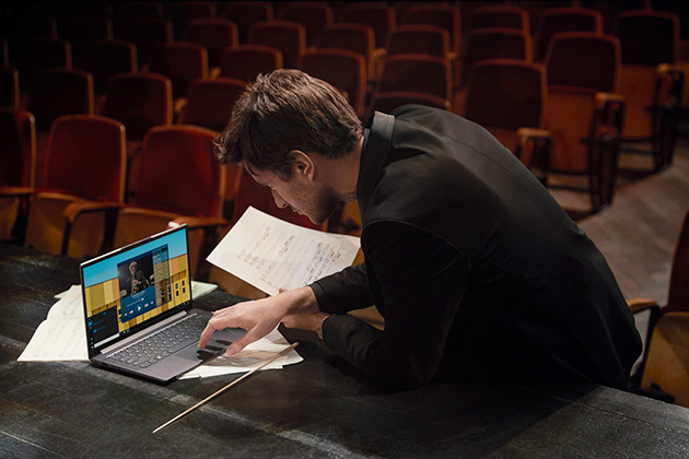 Lenovo Yoga Slim 7 har ett otroligt ljud och en exceptionell bild En man som arbetar på Lenovo Yoga Slim 7 med anteckningar i handen