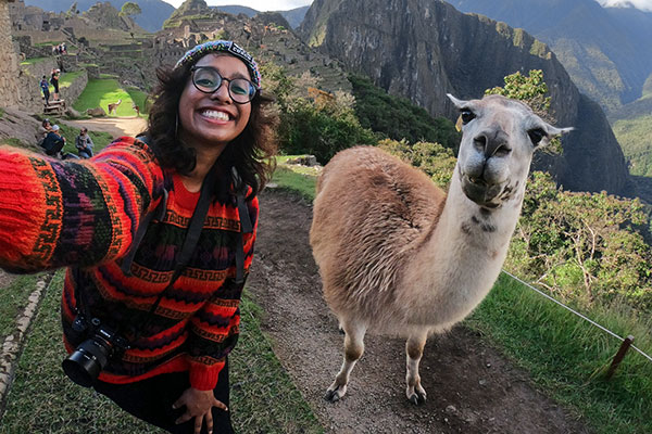 Webbkamera En person som tar en selfie med en lama och berg i bakgrunden