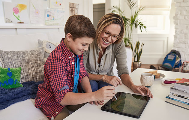 En Chromebook för hela familjen Mamma och son använder en Chromebook