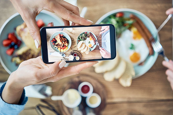 En mobiltelefon som fotograferar en maträtt