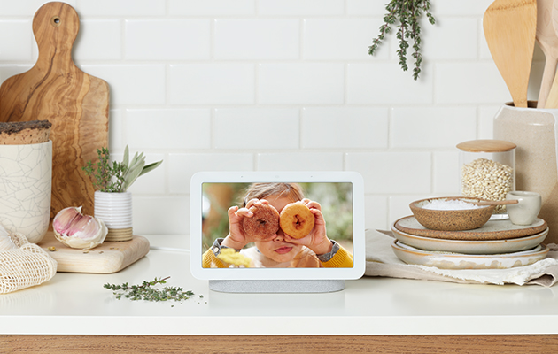 Nest Hub visar dina bästa bilder från Google Foto automatiskt, så att dina favoriter alltid är i bakgrunden Flicka med munkar framför ögonen på en Google Nest Hub