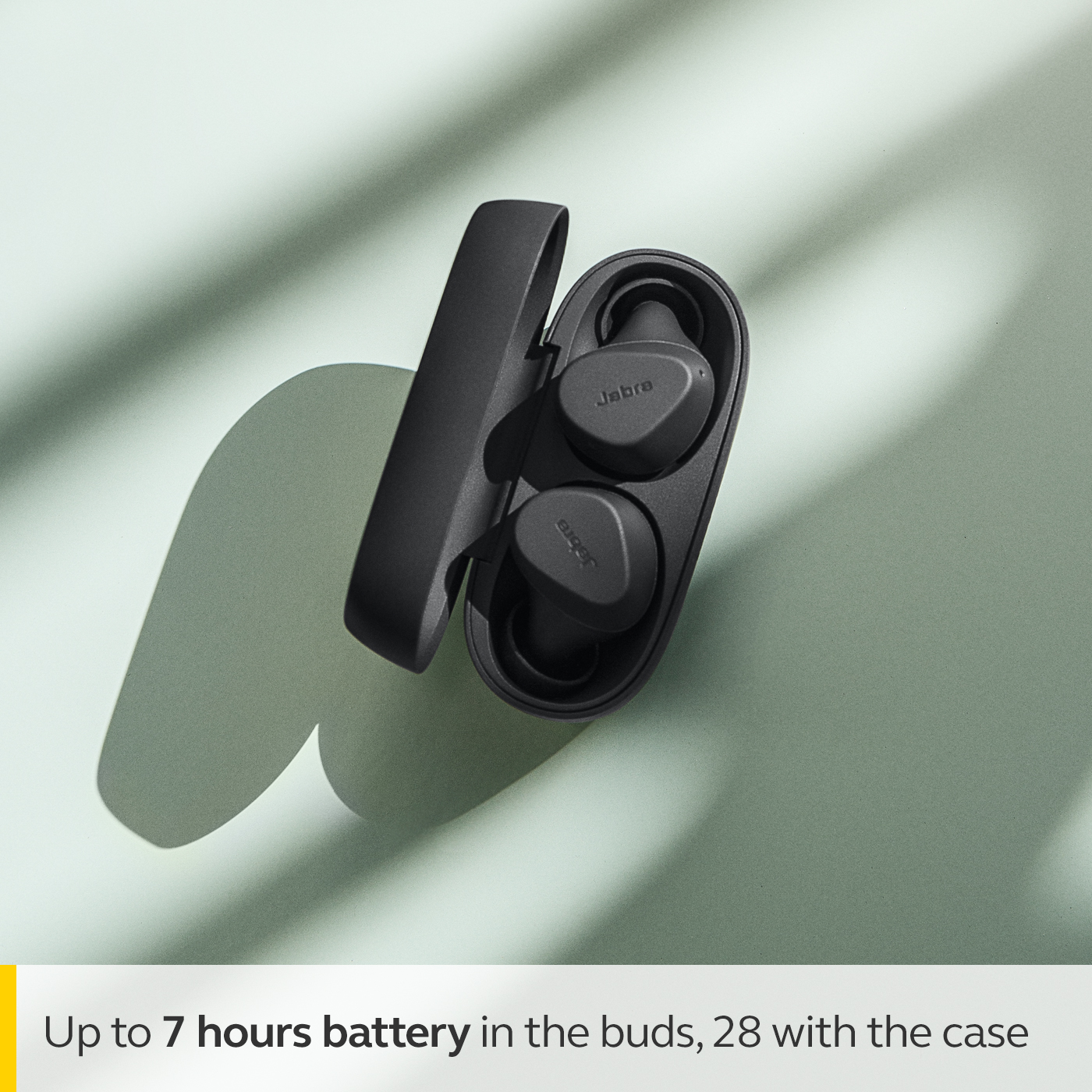 Med upp till 7 timmars batteri i öronsnäckorna, totalt 28 timmar med laddningsfodralet Man med Jabra Elite 3 äkta trådlösa öronsnäckor och text om batteritid