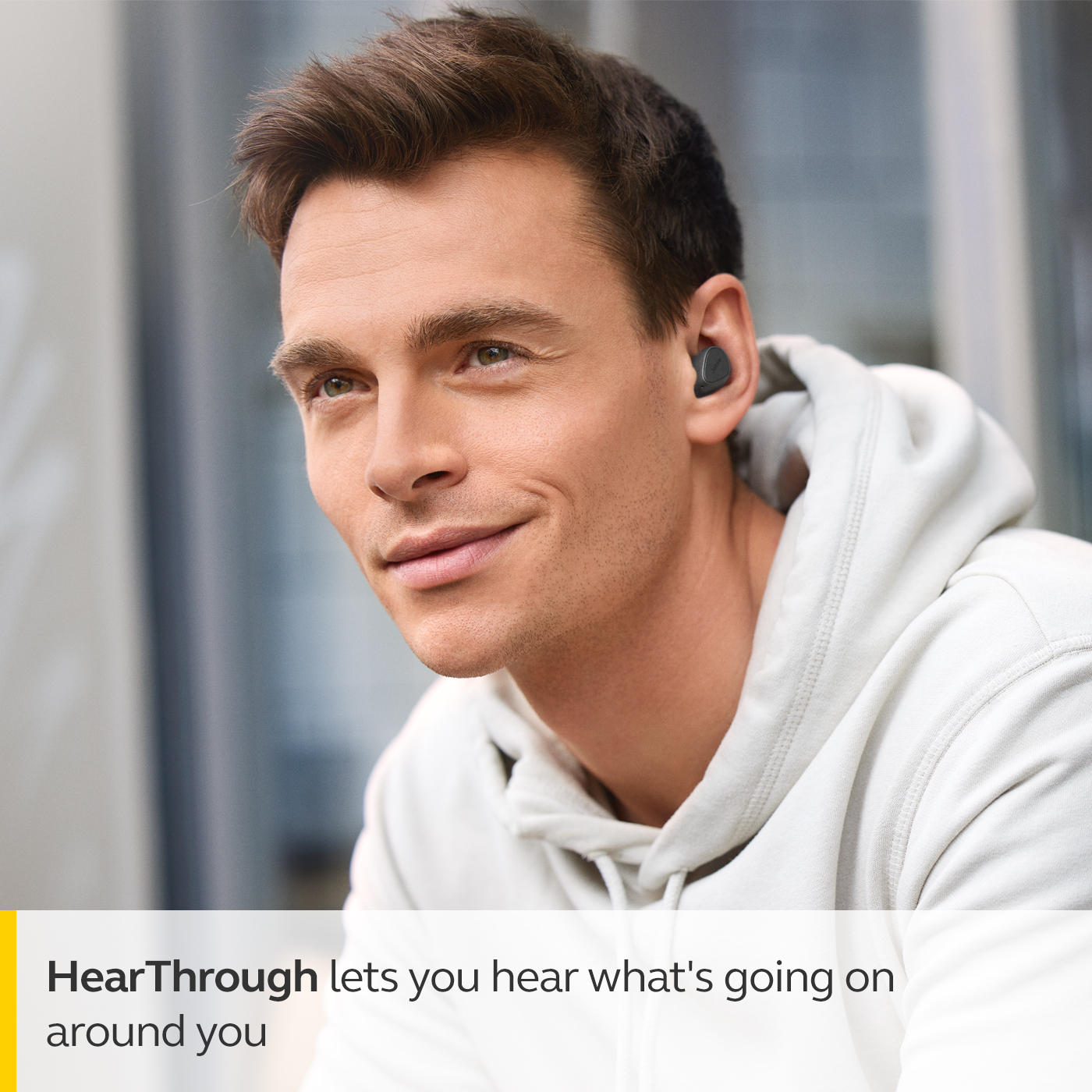 HearThrough-teknologin plockar upp externa ljud och spelar upp dem Man med Jabra Elite 3 äkta trådlösa öronsnäckor och text om HearThrough