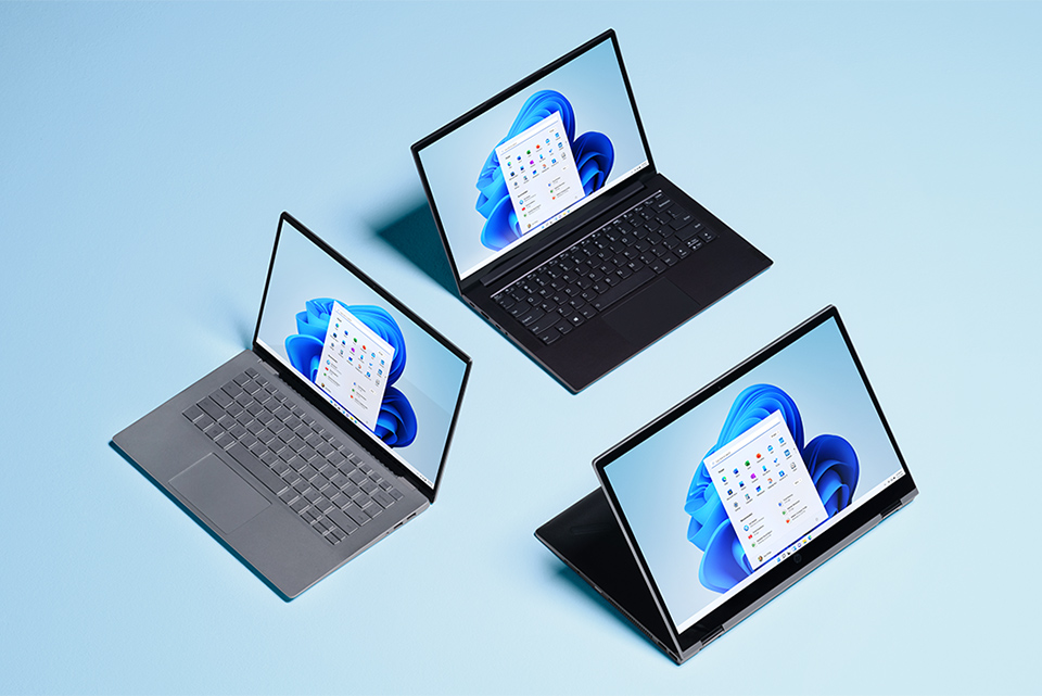 Innovation för oss alla Tre Windows 11-laptops framför blå bakgrund