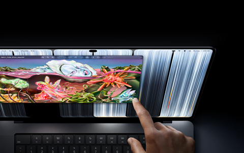 MacBook Pro med PROLED XDR-skärm, rymdsvart, en användare ändrar storlek på ett fönster på skärmen med fingertoppen