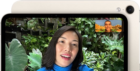 iPad mini sedd framifrån med ett gränssnitt för 12 MP Center Stage-skärmkamera på långsidan, en person ringer ett videosamtal omgiven av grönt lövverk