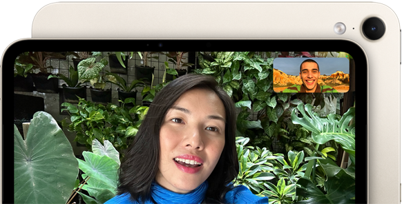 iPad mini sedd framifrån med ett gränssnitt för 12 MP Center Stage-skärmkamera på långsidan, en person ringer ett videosamtal omgiven av grönt lövverk