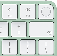 Magic Keyboard i grönt, övre högra hörnet, Touch ID, raderingstangenten och funktionstangenterna för volym
