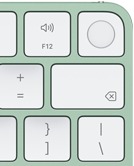 Magic Keyboard i grönt, övre högra hörnet, Touch ID, raderingstangenten och funktionstangenterna för volym