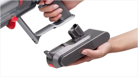Hand som sätter i ett batteri på Dyson V15.